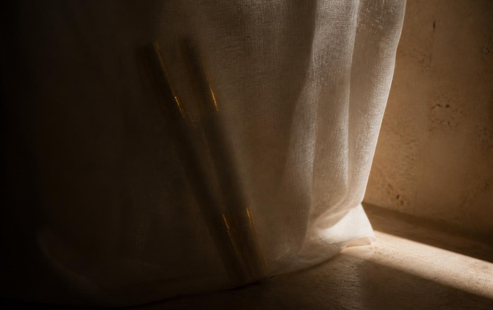Soft silhouettes of future Solareve products behind ivory linen